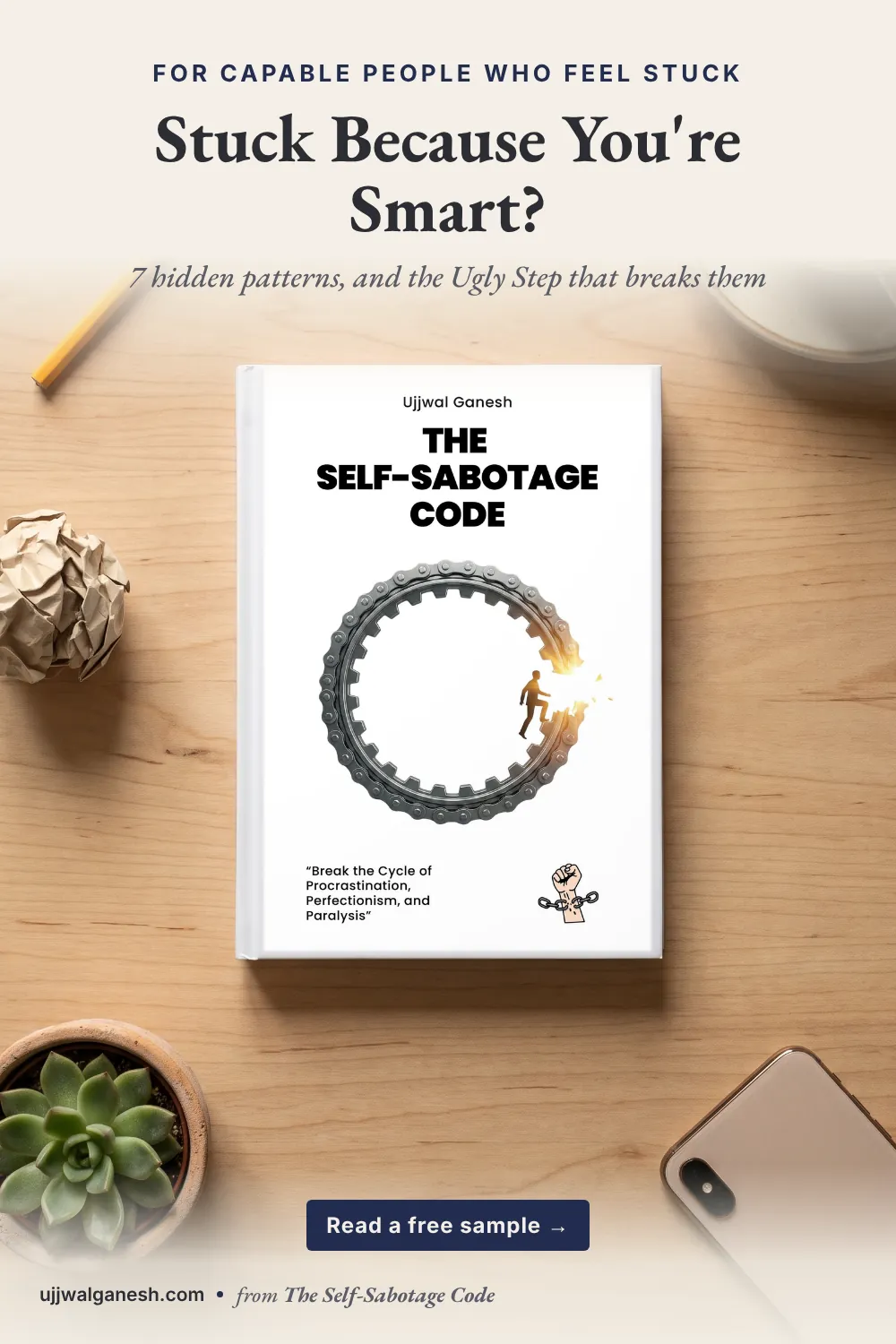 Flat-lay photo of the book The Self-Sabotage Code by Ujjwal Ganesh on a wooden desk with a pencil, a crumpled paper ball, coffee, a succulent and a phone.